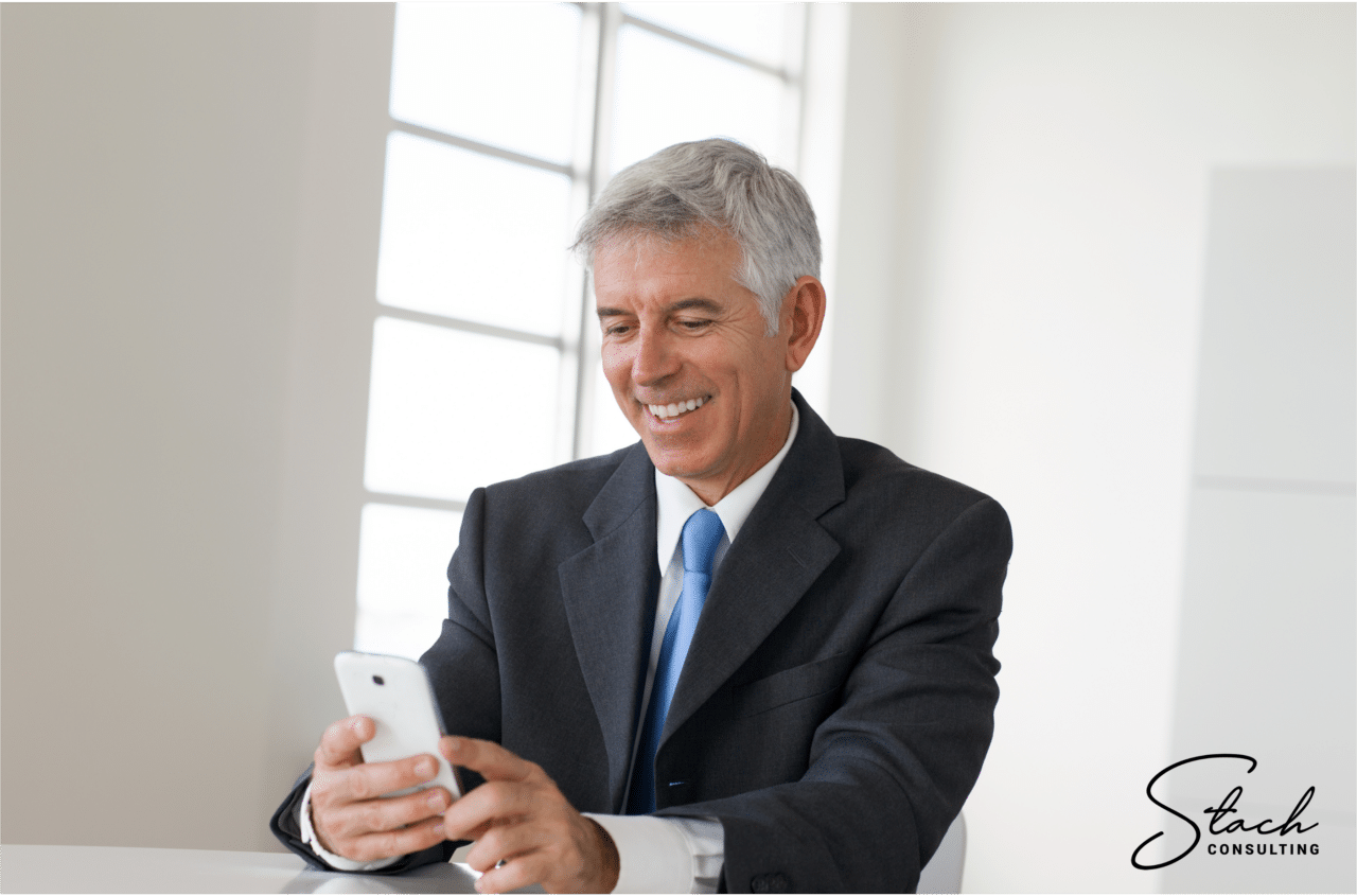 Older business man smiling at phone